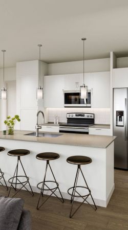 Camber Ridge modern kitchen with a sleek island, barstool seating, stainless steel appliances, and pendant lighting.