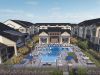 Camber Ridge Apartments aerial view of the pool area surrounded by modern apartment buildings with lush landscaping and outdoor seating areas.