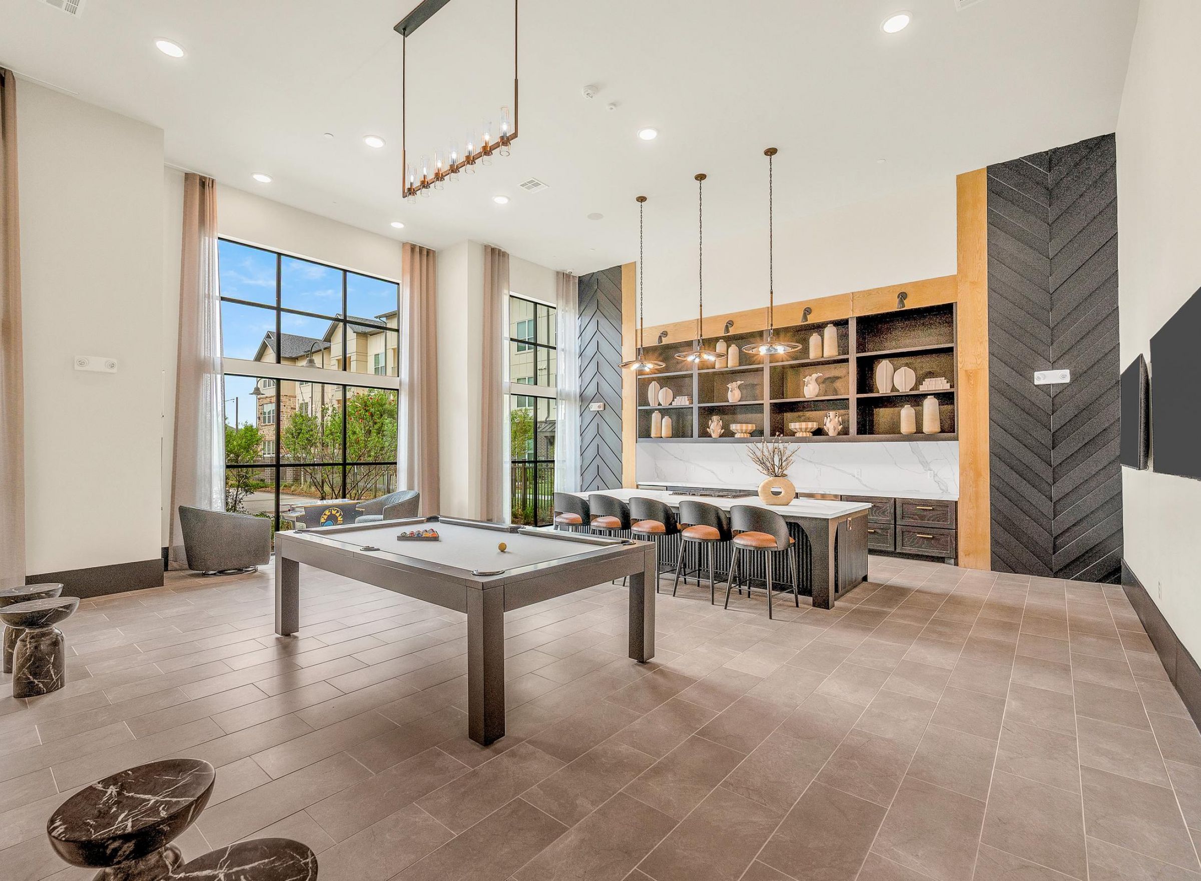 Camber Ridge Modern open-plan lounge with pool table, bar seating, and large windows overlooking an outdoor area.
