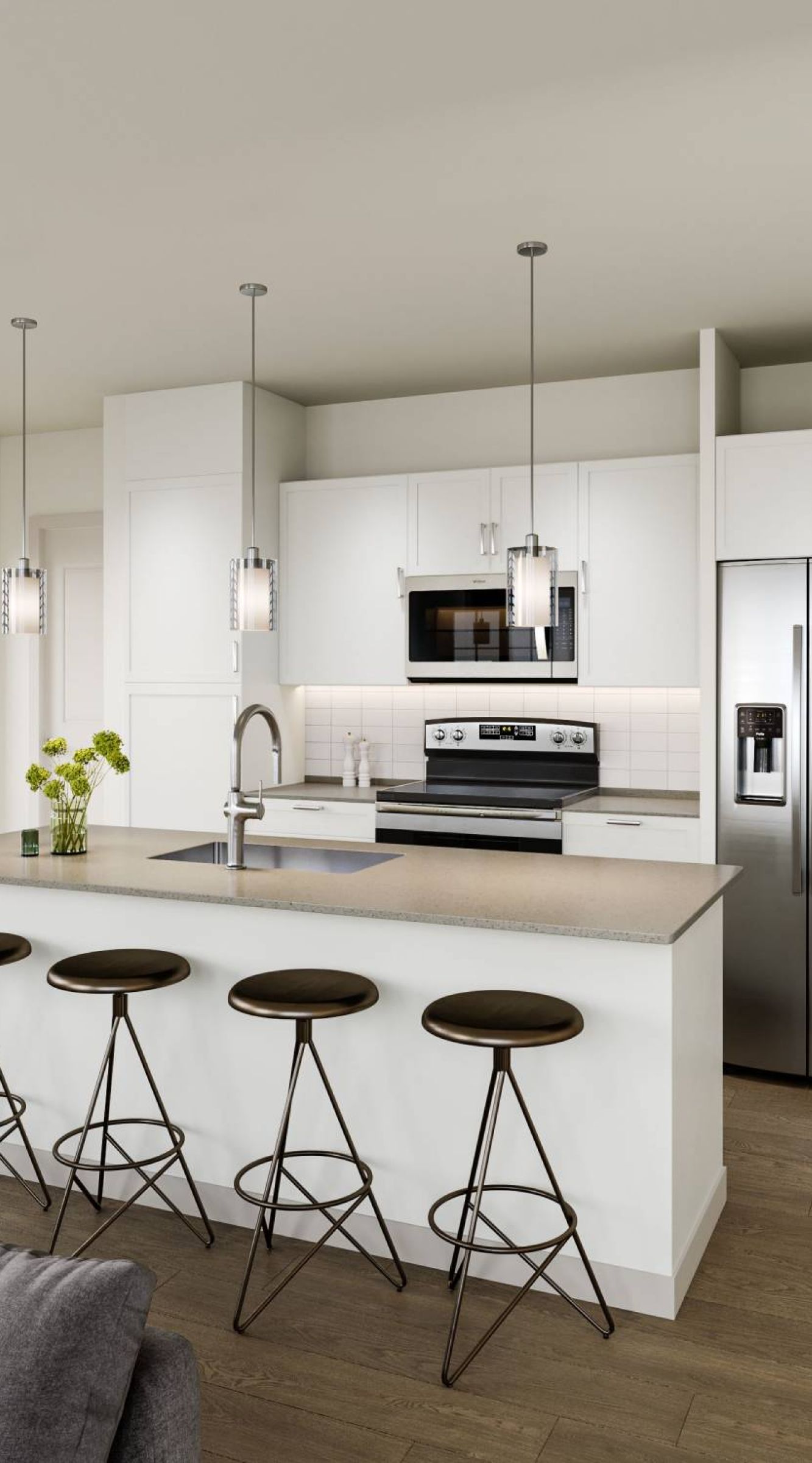 Camber Ridge Modern kitchen with white cabinets, stainless steel appliances, and three bar stools at a central island.