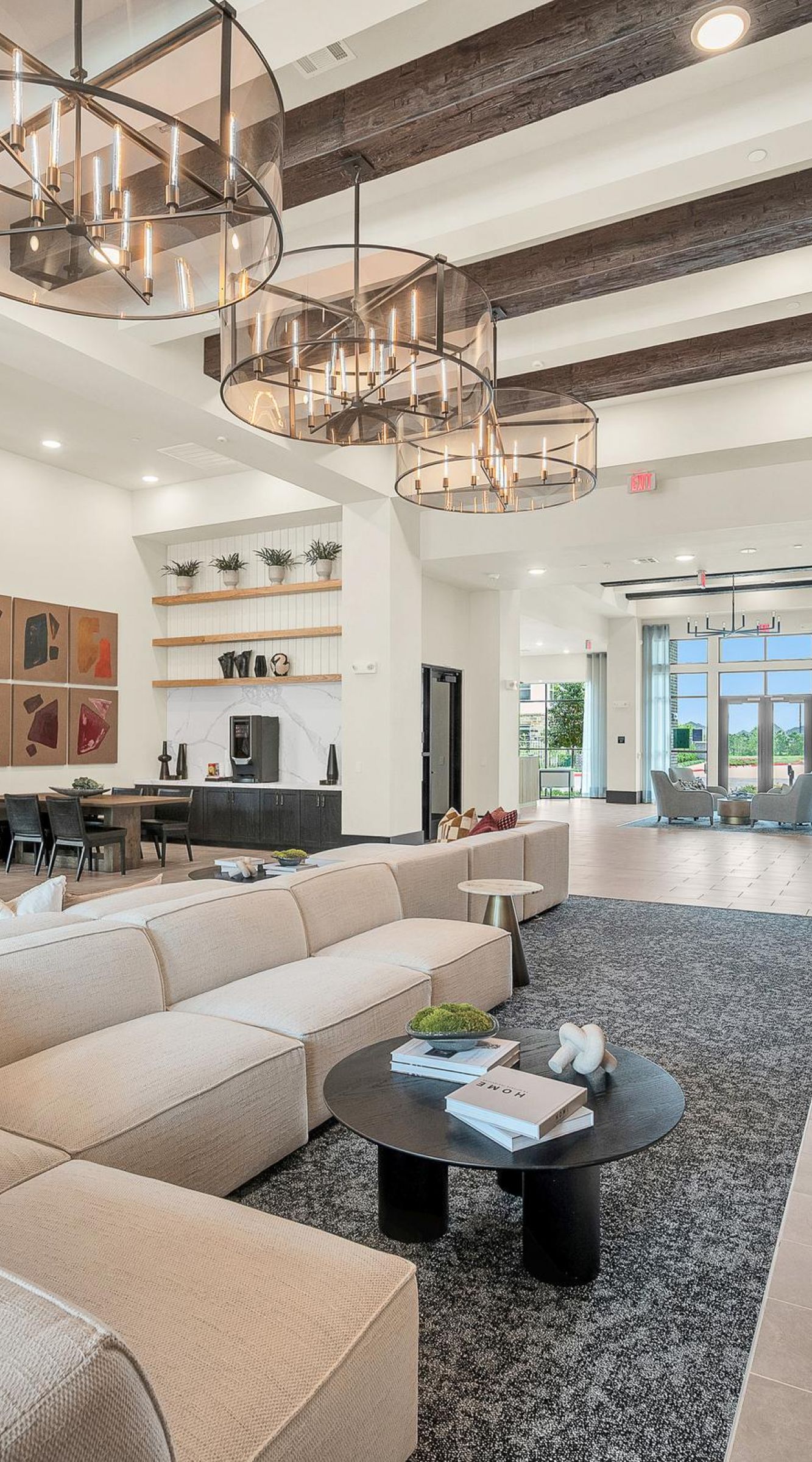 Camber Ridge Modern hotel lobby with beige couches, chandeliers, and wood accents. Large windows in the background.